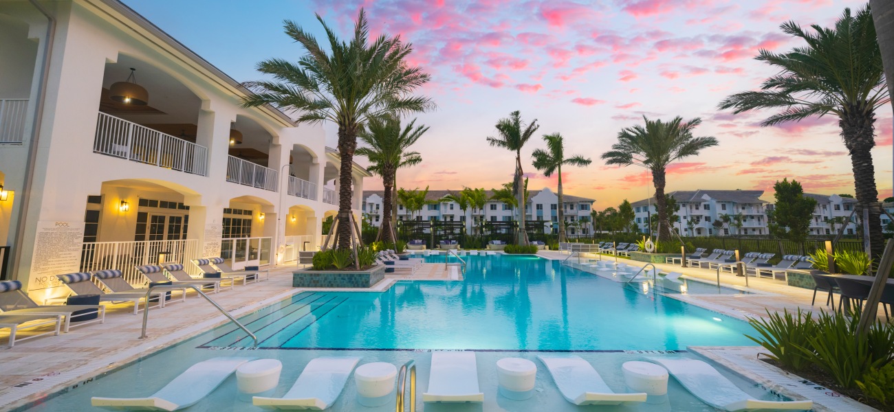 elan palm reserve pool sunset chaise loungers palm trees